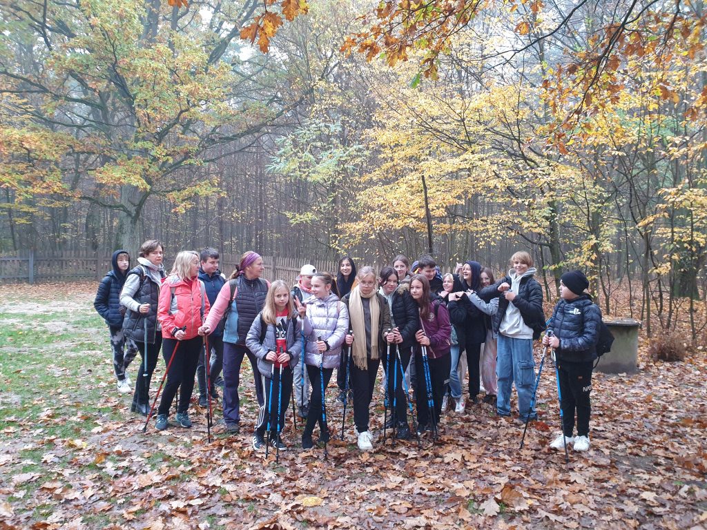 Grupa osób podczas spaceru w lesie
