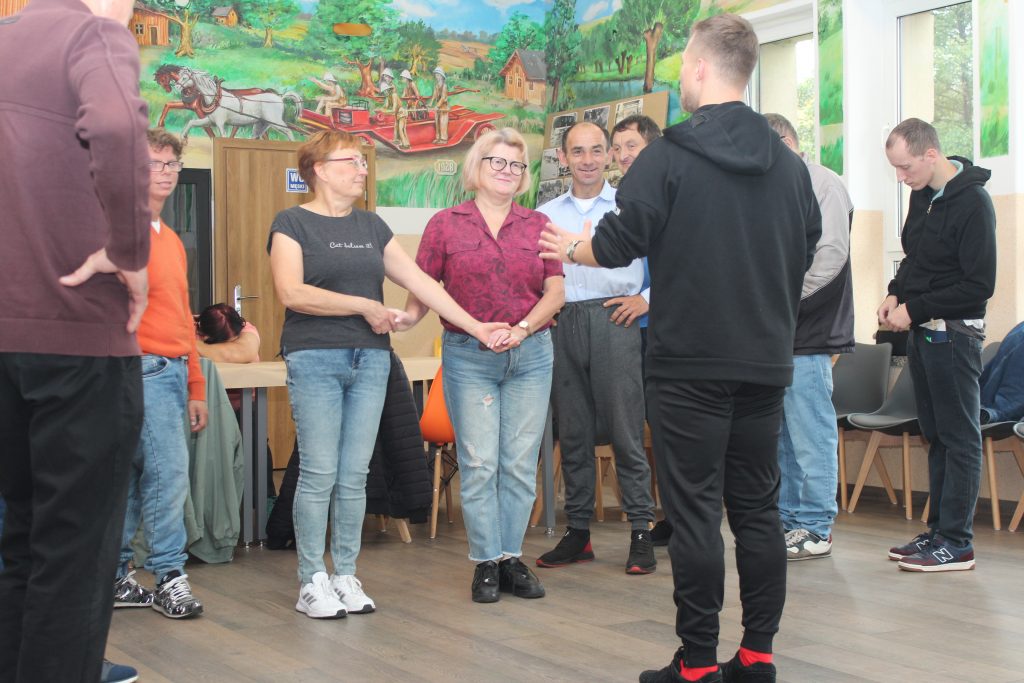 Grupa osób tańczy z nauczycielem tańca