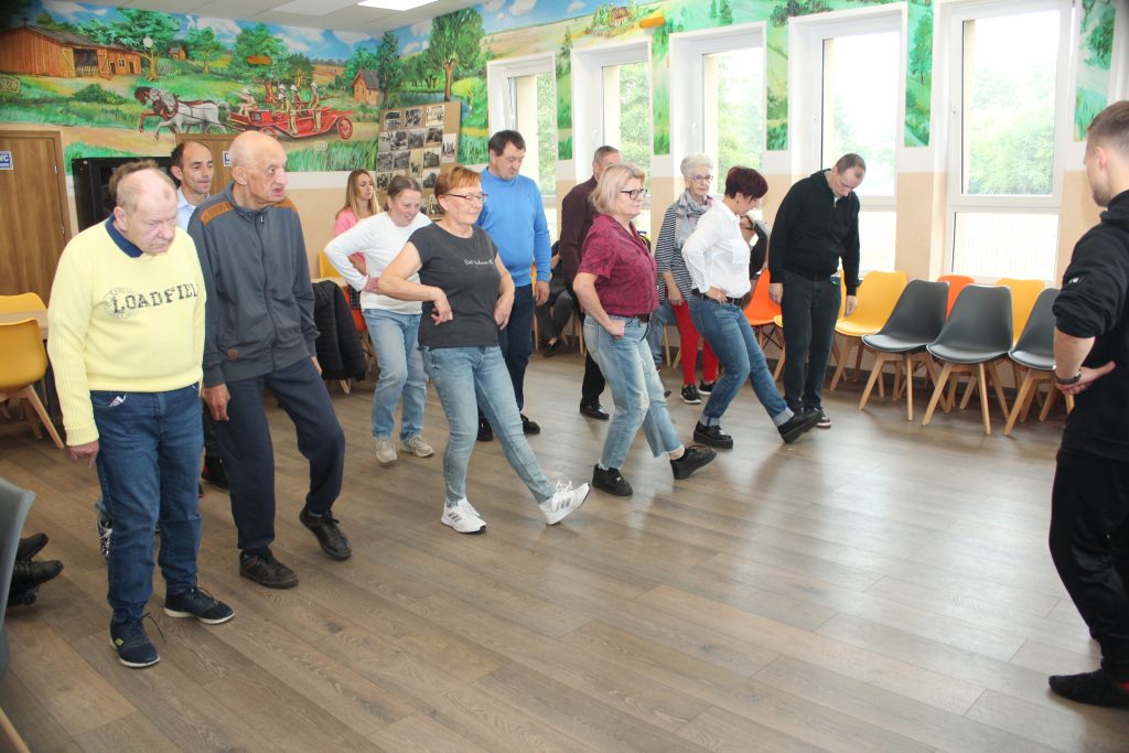 Grupa osób tańczy z nauczycielem