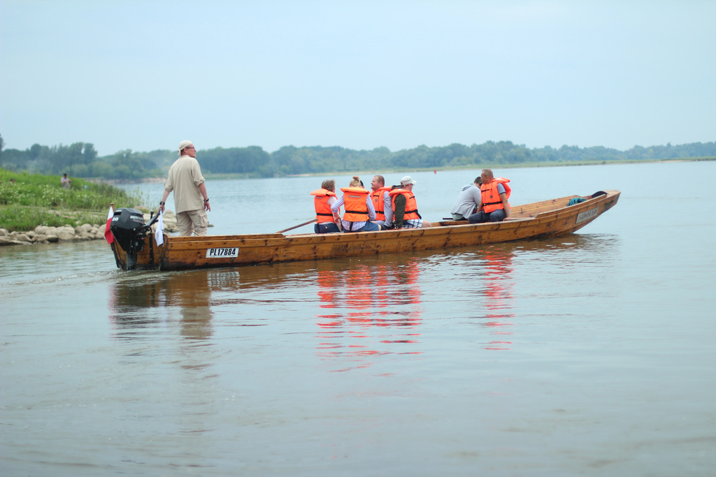 Grupa osób na łodzi w kamizelkach 