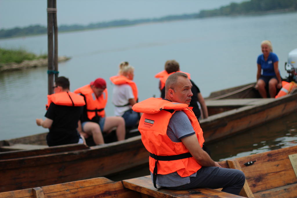 Grupa osób na łodzi w kamizelkach 