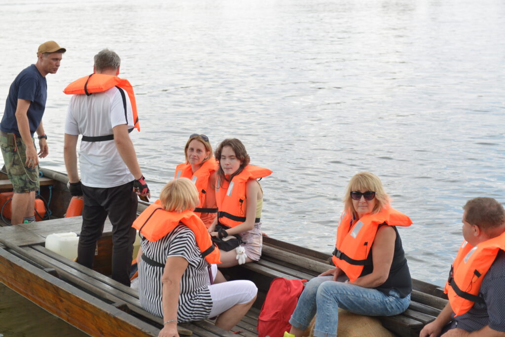 7 osób pływa na łodzi po rzece