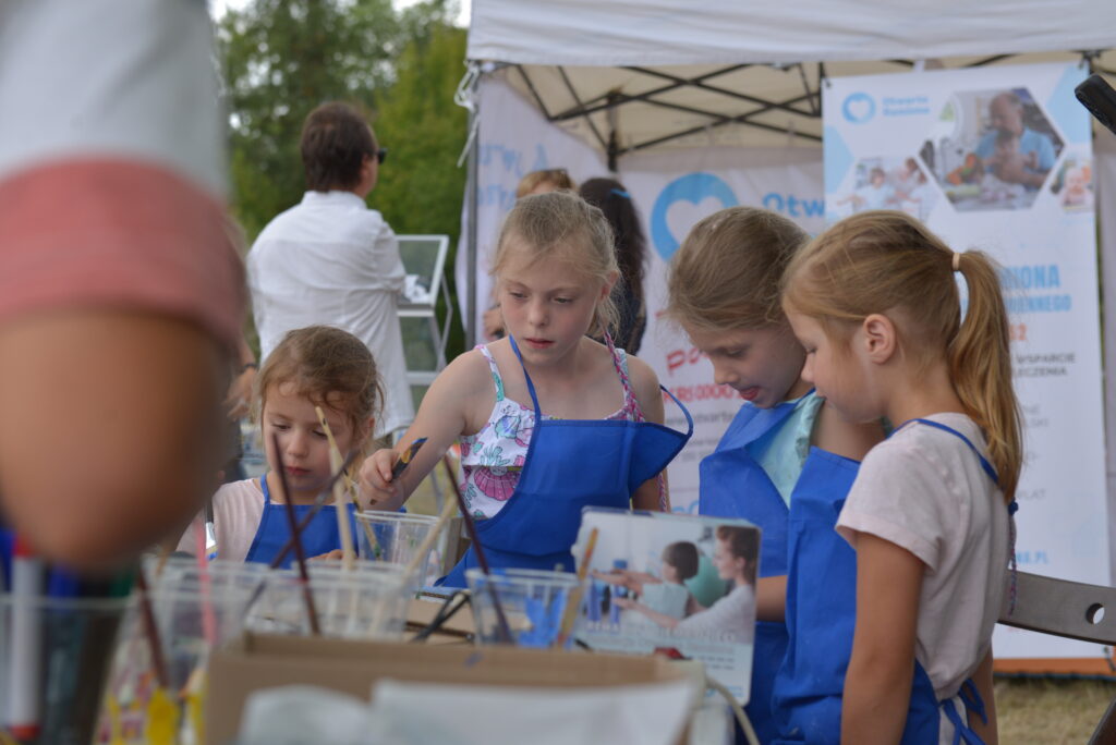 4 dzieci maluje farbami