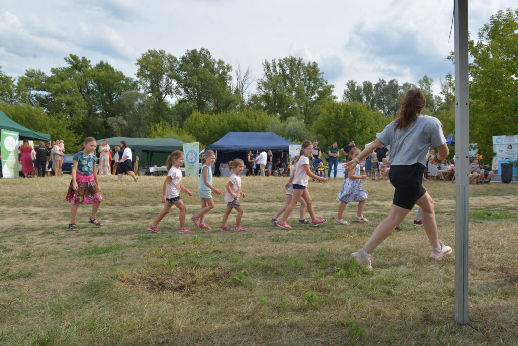 10 dzieci ćwiczy taniec i fitness na świeżym powietrzu