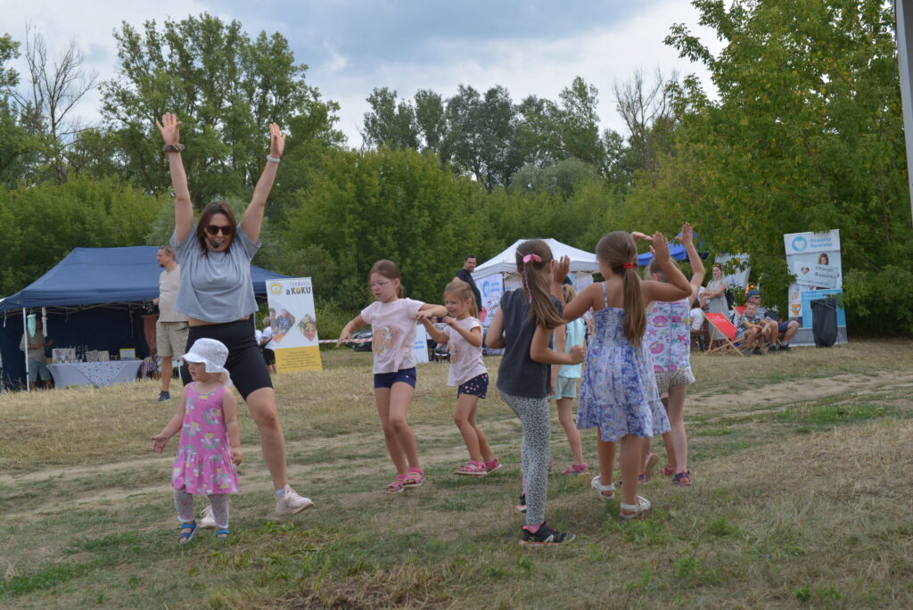 10 dzieci ćwiczy taniec i fitness na świeżym powietrzu